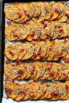 baked sweet potato wedges on a baking sheet lined with parchment paper and sprinkled with seasoning