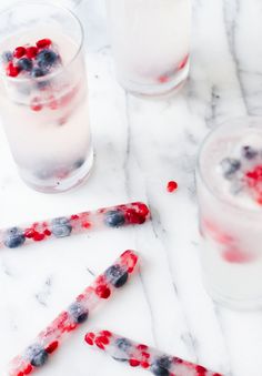 two glasses filled with ice and berries next to each other