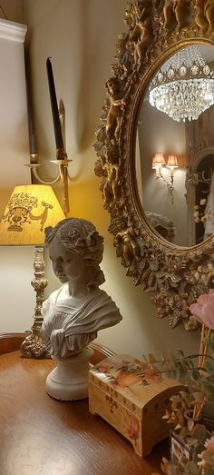 a busturine sits on a table next to a mirror and other decor items