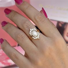 a woman's hand with two rings on it and a ring in the shape of a flower