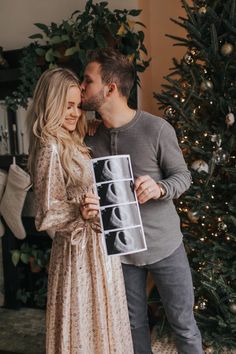 a man and woman kissing in front of a christmas tree with a x - ray