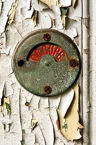 an old rusted metal sign on the side of a building that has peeling paint