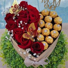 a heart shaped box filled with chocolates and roses