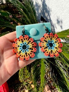 Huichol beaded flower earrings are carefully made by talented hardworking artisans in Mexico. A beautiful accessory to match any outfit and embrace the artistry behind this creation Each set comes with a protective jewelry case Measurements: Flower: 1 3/4" Length: 2 3/4" Bohemian Multicolor Flower Shaped Jewelry, Traditional Flower Earrings For Festival, Artisan Orange Beaded Earrings, Traditional Flower Shaped Earrings For Festivals, Traditional Flower-shaped Earrings For Festivals, Multicolor Floral Beaded Earrings For Festivals, Multicolor Flower Beaded Earrings For Festival, Festival Multicolor Flower Beaded Earrings, Multicolor Flower Earrings For Festival