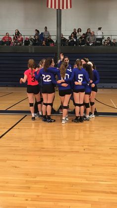 the girls volleyball team huddles together on the court for a moment of prayer