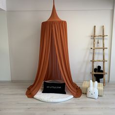 an orange canopy bed in the corner of a room next to a stuffed animal rabbit