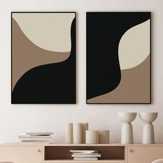 two black and white paintings on the wall above a dresser with vases in front of it