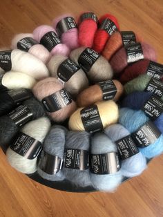 several skeins of wool are arranged in a circle on a wood flooring surface