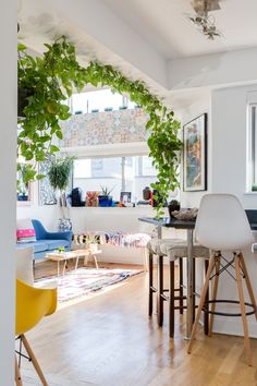 a living room filled with furniture and plants