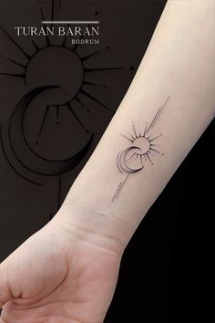 a small sun and moon tattoo on the left inner arm by taran baran