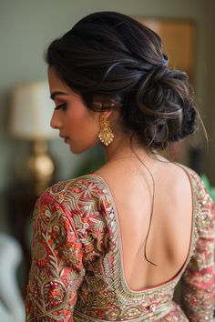 a woman in a red and gold dress with her back to the camera, looking down