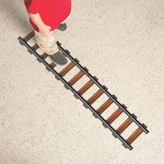 a person standing on top of a train track next to a pair of skis