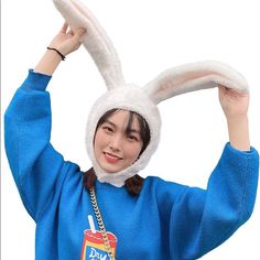 a woman wearing a blue sweatshirt and bunny ears