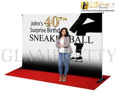 a woman standing in front of a sign for a sports event with the number fortyth surprise birthday sneak ball