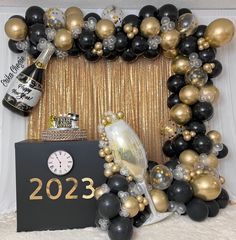 a new year's eve celebration with balloons, champagne and black and gold decorations