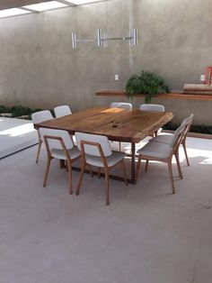 a wooden table with white chairs around it