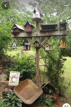 a garden with bird houses and a wheelbarrow