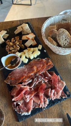 a wooden table topped with meat and cheese