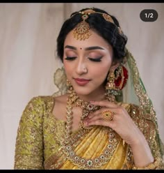 a woman wearing a gold and green bridal outfit