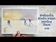 someone holding up a watercolor winter season painting series