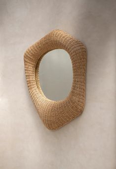 a mirror hanging on the wall next to a sink in a room with white walls