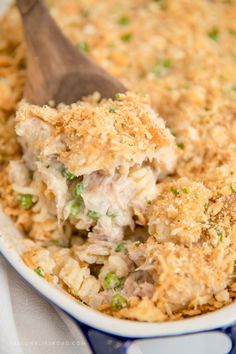 a casserole dish filled with chicken and rice topped with a wooden serving spoon