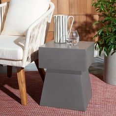 a white chair sitting next to a table on top of a rug