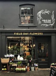 the front of a flower shop that sells flowers