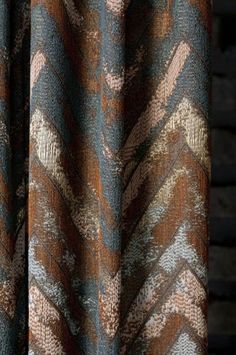 a brown and blue curtain hanging on a wooden wall