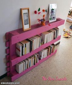 a pink shelf with books and pictures on it