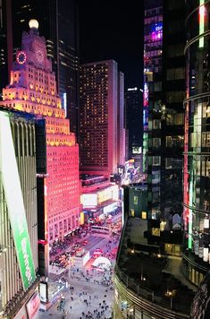 a city street filled with lots of traffic and tall buildings lit up in the night