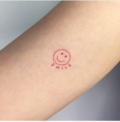 a small smile tattoo on the arm