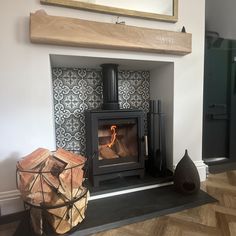 a wood burning stove sitting on top of a wooden floor next to a fire place