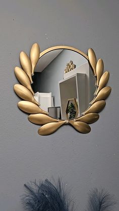 a mirror that is on the side of a wall with some feathers in front of it