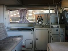 the interior of a camper with bunk beds and appliances