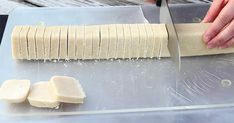 a person is cutting up some food on a metal tray with a knife and chopping board