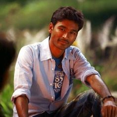 a man sitting on the ground wearing a tie