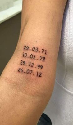 a person with a tattoo on their arm that has numbers and dates tattooed on it