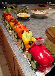 a train made out of vegetables sitting on top of a counter next to plates and bowls