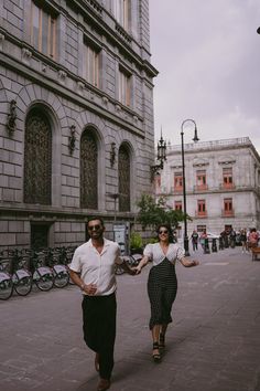 two people walking down the street holding hands