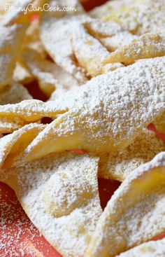 some powdered sugar on top of an orange plate with apples in the back ground