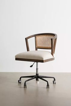 an office chair sitting on top of a wooden table next to a white wall and floor