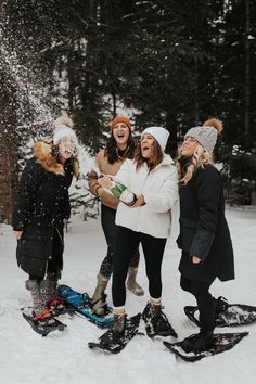 three women laughing while standing in the snow