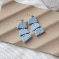 three pairs of blue earrings sitting on top of a table