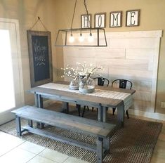 a dining room table with benches and lights hanging from it's ceiling above the table