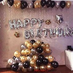 a birthday party with balloons, streamers and stars on the wall in front of it