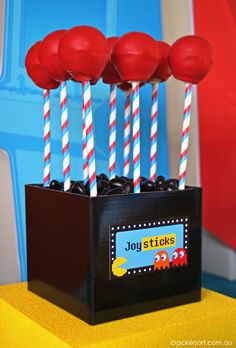 some red and white striped lollipop sticks in a black box on a yellow table