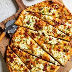 sliced pizza on cutting board with serving utensils