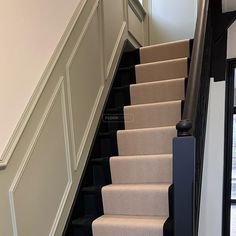 a set of stairs leading up to a second story door in a home with white walls and black railings