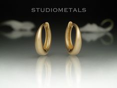 Elegant and simple matte 14K gold huggie hoop earrings, 12mm in diameter. Comfortable and made to last a lifetime, these huggies are perfect to wear everyday, 24/7. Shower in them, sleep in them, go anywhere and everywhere! A thoughtful, high quality gift for him or for her. * Handmade in solid 14K yellow, white or rose gold. * Outside diameter of 12mm. * Inside diameter of 8.5mm. * The bottom width is 3mm and tapers toward the top to a standard size ear wire. * Approximate weight of 2.6 grams for the pair in 14K gold. * Available in a matte or polished finish. Please allow us about 2 weeks to make your earrings prior to shipping. We ship FedEx Ground or Canada Post Xpresspost with tracking and a signature required for delivery. Shipping upgrades available at checkout. The video and photos Polished Finish Huggie Earrings For Wedding, Gold Huggie Hoop Earrings, Gold Huggie Earrings, Gold Alloys, Huggie Earrings, Canada Post, Huggie Hoop Earrings, Jewelry Earrings Hoops, Leave In